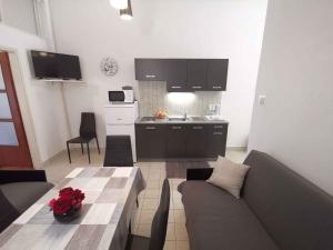 a living room with a couch and a table and a kitchen at Apartment in Crikvenica 27813 in Dramalj