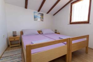 um quarto com uma cama com lençóis roxos e uma janela em Apartments in Crikvenica 31165 em Crikvenica