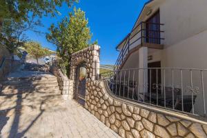 una pared de piedra junto a un edificio con una valla en Apartments in Crikvenica 31165 en Crikvenica