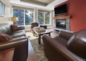 sala de estar con muebles de cuero y chimenea en Star Suite -Luxurious condo with 3 fireplaces, and open Pool!, en Canmore