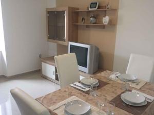 ein Esszimmer mit einem Tisch und einem TV in der Unterkunft Apartment in Banjole/Istrien 34141 in Banjole