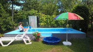 Eine Frau, die auf einem Stuhl neben einem Pool sitzt. in der Unterkunft Apartment in Keszthely/Balaton 18986 in Keszthely