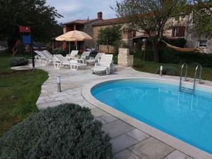 a swimming pool with lounge chairs and an umbrella at Holiday home in Dignano in Vodnjan