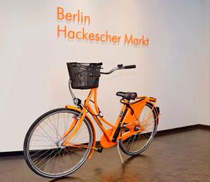 an orange bike parked in front of a wall at easyHotel Berlin Hackescher Markt in Berlin
