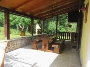 a patio with a table and benches on a porch at Holiday home in Turke/Gorski Kotar 34884 in Turke