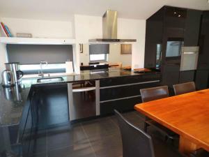 a kitchen with black cabinets and a wooden table at Apartments in Rovinj/Istrien 34602 in Rovinj