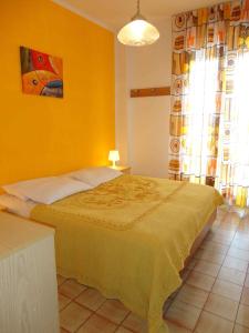 una camera con un letto con una parete gialla di Apartments in Porto Santa Margherita 24778 a Porto Santa Margherita di Caorle