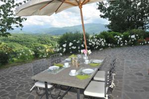 a table with chairs and an umbrella on a patio at Apartment in Vicchio - Toskana 31169 in Vicchio