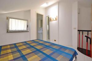 リニャーノ・サッビアドーロにあるApartments in Lignano 21597のカラフルなベッドが備わるベッドルーム1室が備わります。
