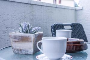 einen Tisch mit zwei Kaffeetassen und einer Topfpflanze in der Unterkunft Apartments in Vantacici - Insel Krk 13154 in Vantačići