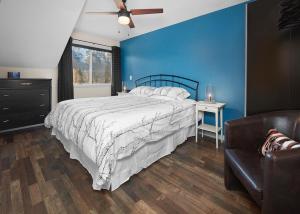 a bedroom with a bed and a blue wall at Mountain Gate - Pet Friendly 2BR w Mountain Views and open hot tub in Canmore