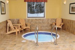 bañera de hidromasaje en una habitación con sillas y mesa en Trend Mountain Hotel & Conference Centre, en Tumbler Ridge