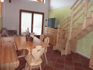 a living room with a wooden table and stairs at Apartments in Comano 24163 in Comano Terme