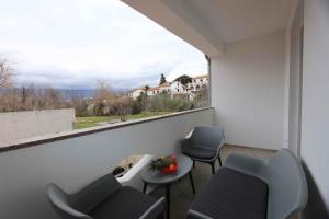 a balcony with two chairs and a table and a window at Apartments in Silo/Insel Krk 26753 in Šilo