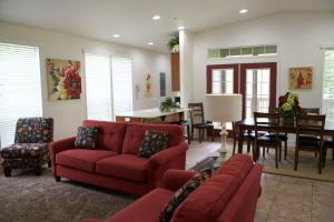 a living room with a red couch and a dining room at Wonder Valley Ranch Resort in Pine Flat Lake