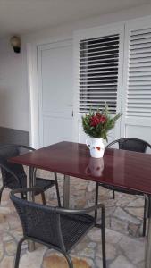 una mesa de madera con un jarrón de flores. en Apartments in Vinjerac/Paklenica Riviera 27673, en Vinjerac