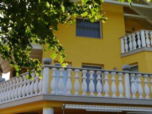 Biały balkon w żółtym budynku w obiekcie Apartments in Alsopahok/Balaton 27597 w mieście Alsópáhok