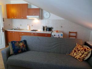 uma sala de estar com um sofá e uma cozinha em Apartment Volosko 15685 em Volosko