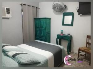 a bedroom with a bed and a green cabinet and a mirror at Hotel Media Luna in Guadalajara