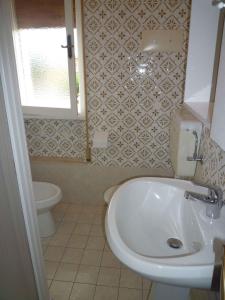 uma casa de banho com um lavatório e um WC em Apartments in Eraclea Mare 25693 em Eraclea Mare