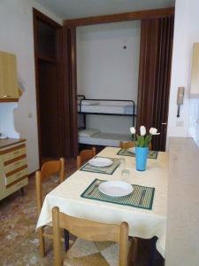 uma mesa de jantar com um prato e flores em Apartments in Eraclea Mare 25693 em Eraclea Mare