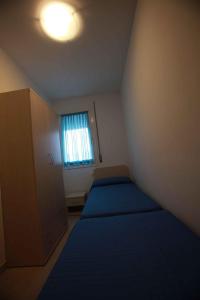 Habitación pequeña con 2 camas y ventana en Apartments in Rosolina Mare 25008, en Rosolina Mare