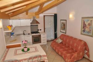 ピエーヴェ・ディ・レードロにあるApartments in Pieve di Ledro/Ledrosee 22671のリビングルーム(赤いソファ付)、キッチン
