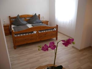 a bedroom with a bed and a vase with purple flowers at Holiday home in Balatonszentgyörgy 20188 in Balatonszentgyörgy +36 photos