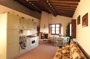 una cocina con electrodomésticos blancos y una mesa en una habitación en Agriturismo Il Poderino, en Asciano