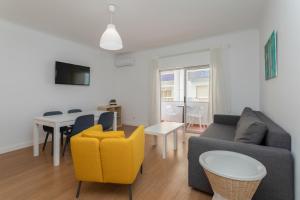 un salon avec un canapé et une table dans l'établissement AL - Apartamentos Vista Mar, à Quarteira