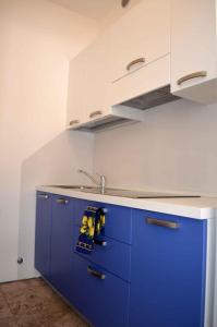 eine Küche mit blauen Schränken und einem Waschbecken in der Unterkunft Apartment in Eraclea Mare 25149 in Eraclea Mare