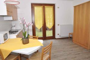 レードロにあるApartments in Pieve di Ledro/Ledrosee 22632のキッチン、ダイニングルーム(テーブル、黄色のテーブル、椅子付)