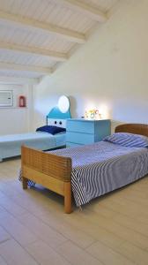 a bedroom with two beds and a bench at Apartment in Lido Sant´Angelo 21008 in Torre Pinta