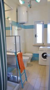 a bathroom with a toilet and a towel on a chair at Apartment in Lido Sant´Angelo 21008 in Torre Pinta