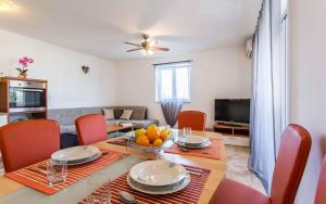 a living room with a dining room table with chairs and a television at Apartment in Silo/Insel Krk 13580 in Šilo