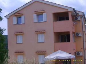 różowy budynek z białym parasolem przed nim w obiekcie Apartment in Silo - Insel Krk 13580 w mieście Šilo