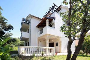 a white house with a white fence and a tree at Apartments in Silo/Insel Krk 13513 in Šilo