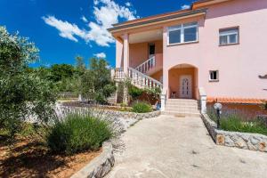 a large pink house with a driveway at Apartments in Silo/Insel Krk 13513 in Šilo