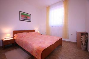 a bedroom with a large bed and a window at Apartments in Silo/Insel Krk 13442 in Šilo