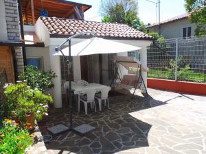 un patio con una mesa y una sombrilla en One-Bedroom Holiday home in Umag - Istrien 12158, en Umag
