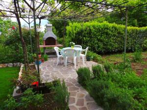 a patio with a table and chairs in a garden at Apartment in Labin/Istrien 8875 in Raša