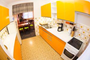 uma cozinha com armários amarelos e brancos e uma mesa em Holiday home Benecko/Riesengebirge 2230 em Benecko