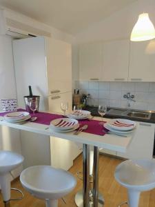 a kitchen with a table with plates and wine glasses at Apartment in Klimno/Insel Krk 12479 in Klimno