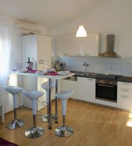 a kitchen with a table and bar stools at Apartment in Klimno/Insel Krk 12479 in Klimno