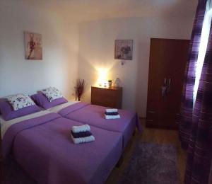 two beds in a bedroom with purple sheets and towels at Apartment in Matulji 17036 in Matulji