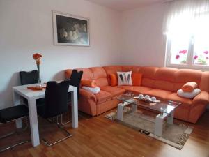 uma sala de estar com um sofá laranja e uma mesa em Apartment in Matulji 17036 em Matulji