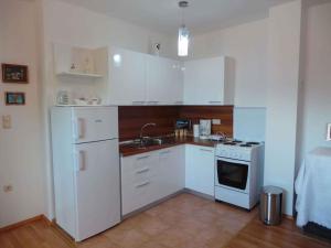 uma cozinha com armários brancos e um frigorífico branco em Apartment in Matulji 17036 em Matulji