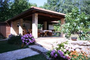 un pabellón de piedra con una mesa de picnic en un jardín en Apartments in Silo - Insel Krk 13442, en Šilo