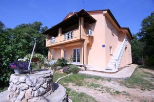 Una pequeña casa con un muro de piedra delante. en Apartments in Silo - Insel Krk 13442, en Šilo