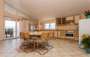eine Küche mit einem Tisch und Stühlen sowie einem Kühlschrank in der Unterkunft Apartment in Silo/Insel Krk 13488 in Šilo